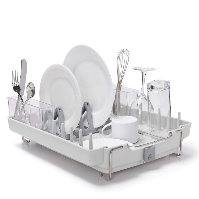 OXO Good Grips Foldaway Dish Rack holding plates, glasses, utensils, and a mug